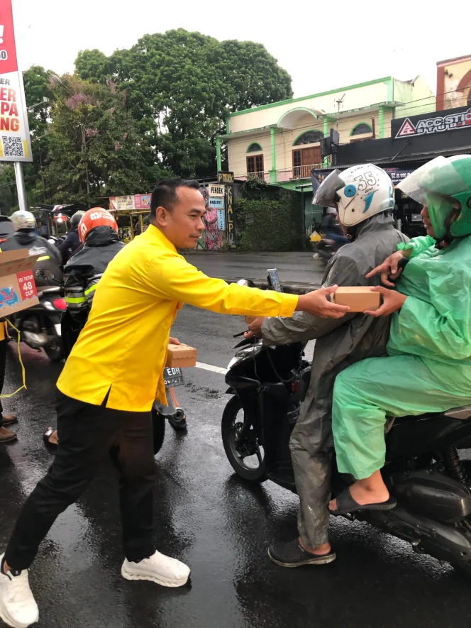 
					Ketua DPD Golkar Kota Malang, Djoko Prihatin, tampak berdiri di tepi jalan bersama puluhan kader, menyapa satu per satu warga yang menerima bingkisan berbuka.
