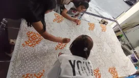 Para perajin batik tengah mewarnai batik Malangan dengan tema